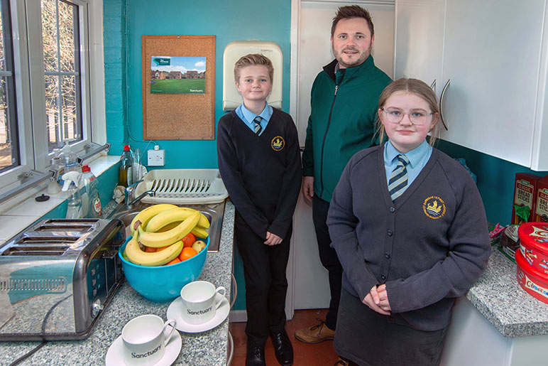 Children and construction manager in the new kitchen at St Barnabas school