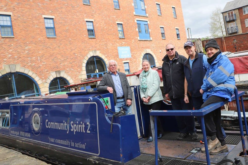 EMCBP and Tameside Canal Boat Trust volunteers Five people standing on a moored boat smiling