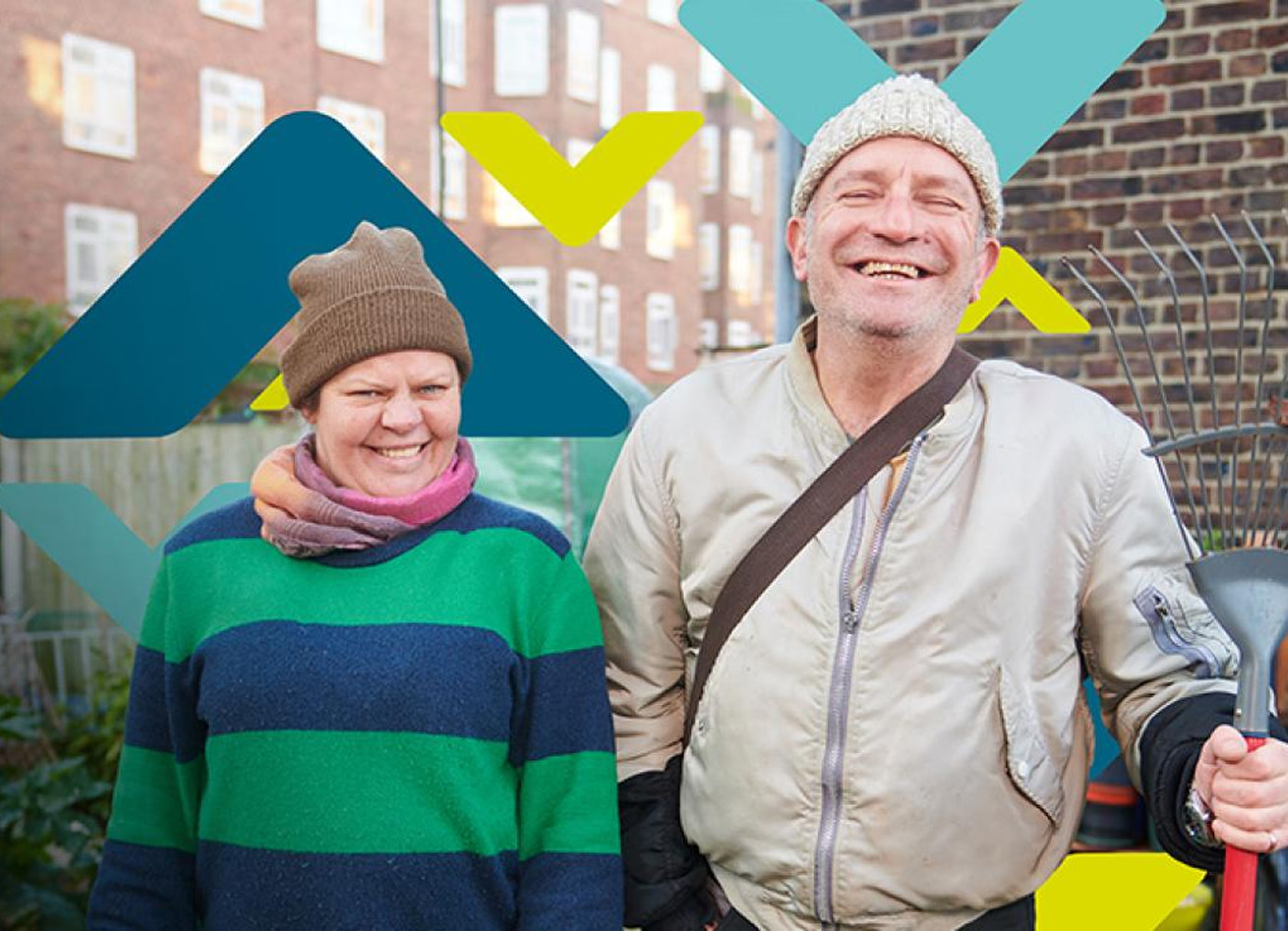 Two residents smiling, standing in an allotment Two residents smiling, standing in an allotment