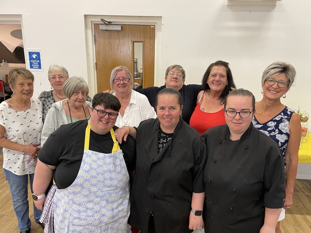 Blether cafe volunteers A group of people standing in a community centre smiling