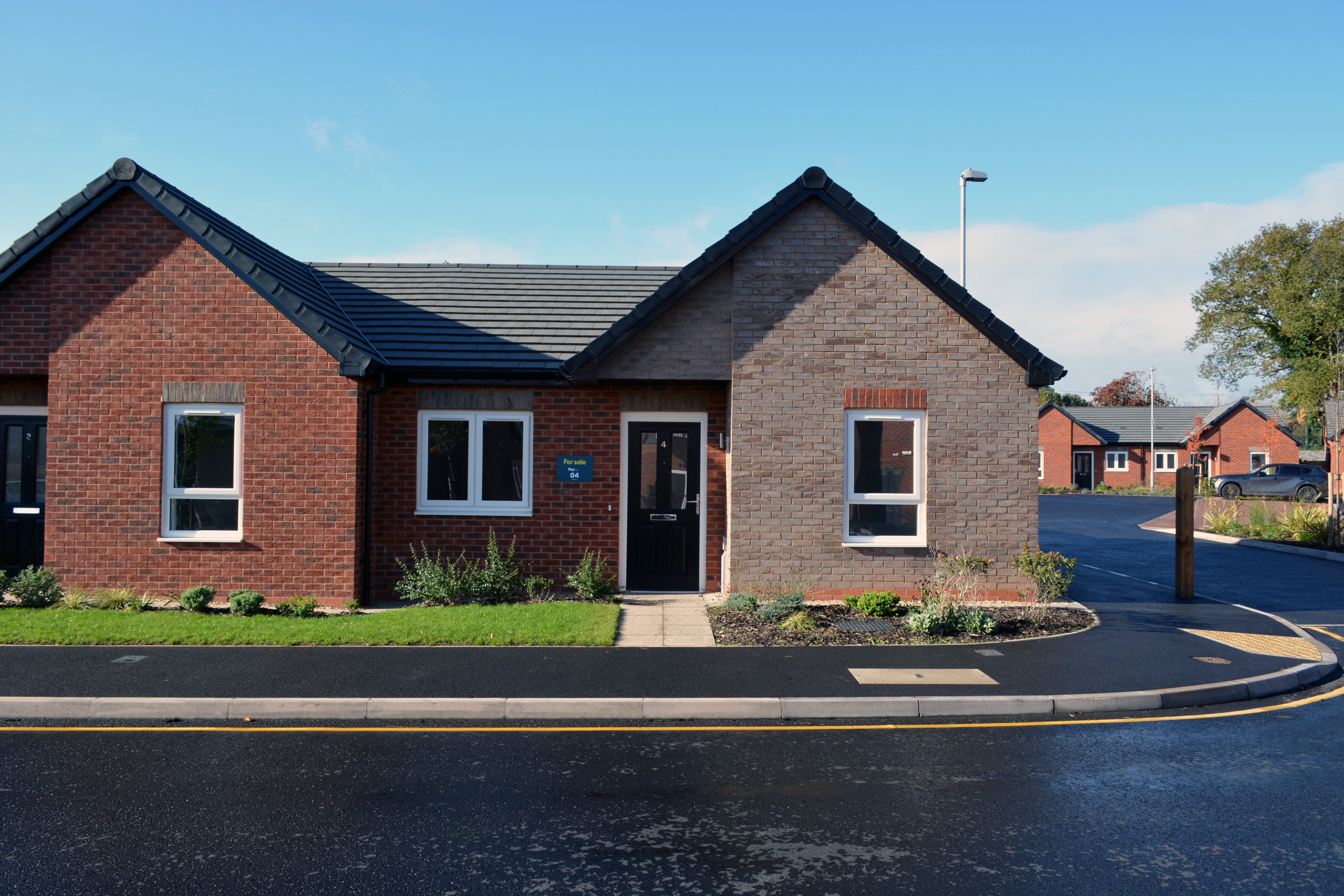 A grey brick semi detached bungalow