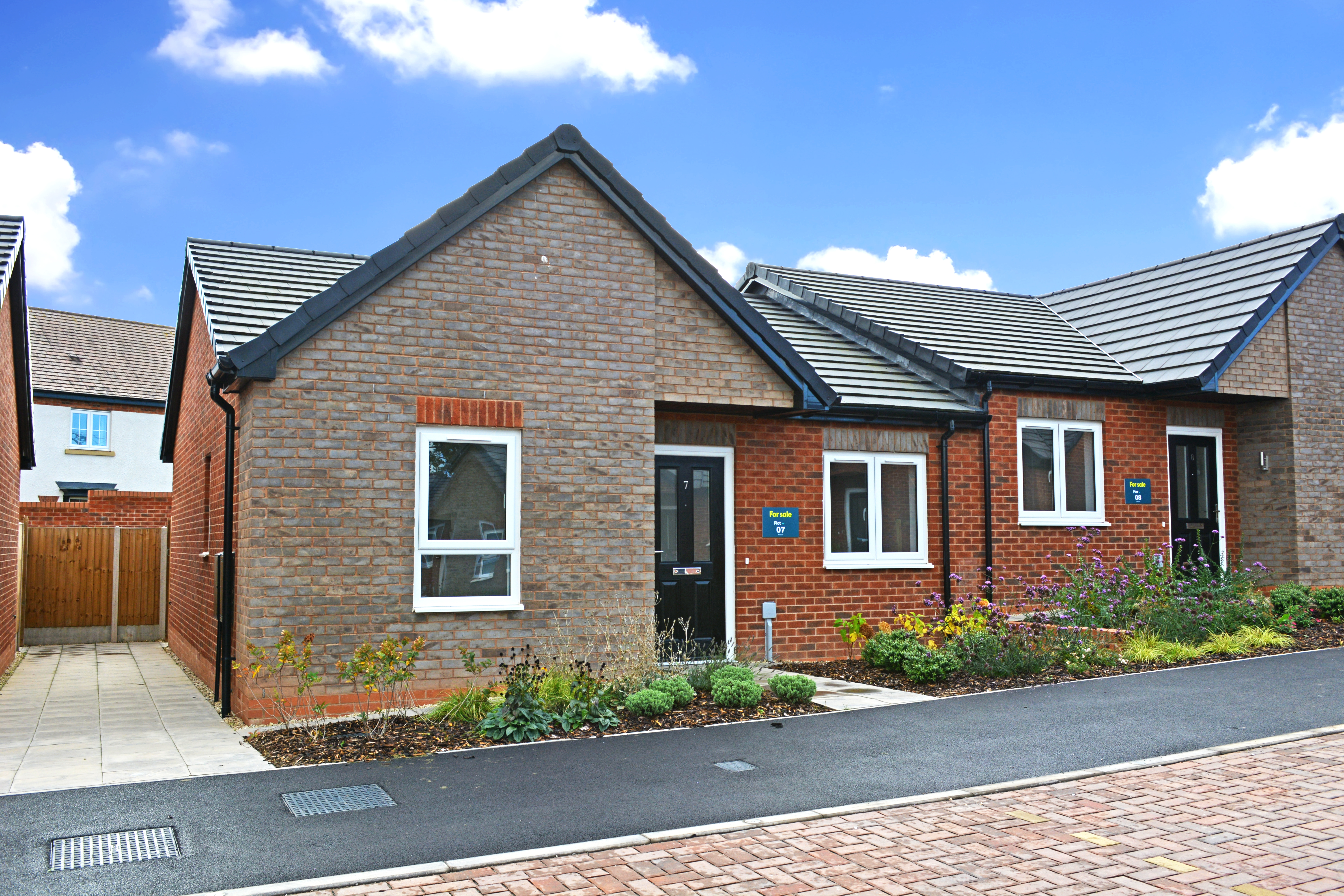 A grey brick semi-detached bungalow