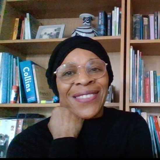 Portrait photo of Georgia Blackwood sat in front of a bookcase.