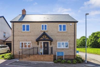 Front exterior of a two-story brick house with black front door and small landscaped area.