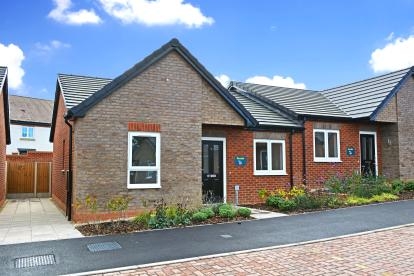 A grey brick semi-detached bungalow