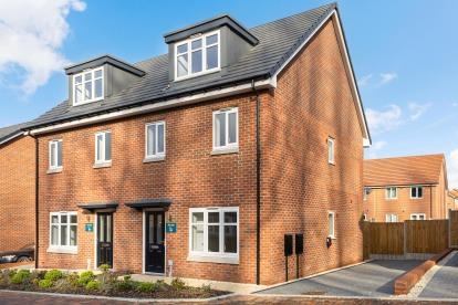 Front view of a red brick semi-detached house with white windows and a black front door.
