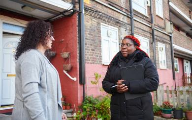 Sanctuary staff speaking to a resident outside their home