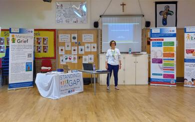 Standing in the Gap representative giving a presentation in a school hall