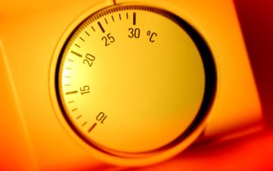 A thermostat is shown surrounded by a warm orange glow