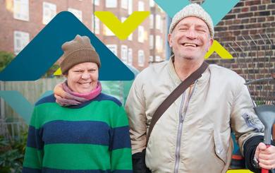 Two residents smiling, standing in an allotment