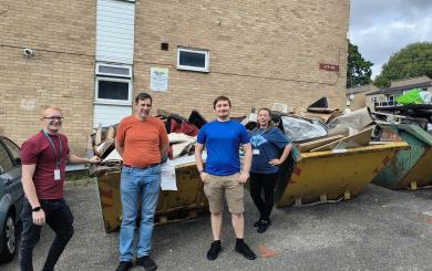 Sanctuary staff stand in front of several full skips