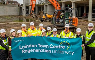 Sanctuary staff members and Councillors pose at the Laindon site with a banner that reads 'Laindon Town Centre Regeneration underway'