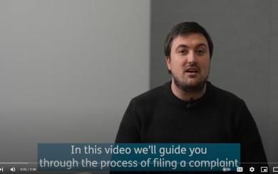A man talks to the camera, captions read 'In this video we'll guide you through the process of filing a complaint'