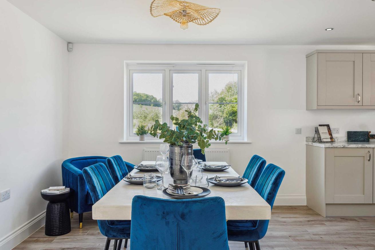 Close-up of dining area with table set for six and blue chairs.