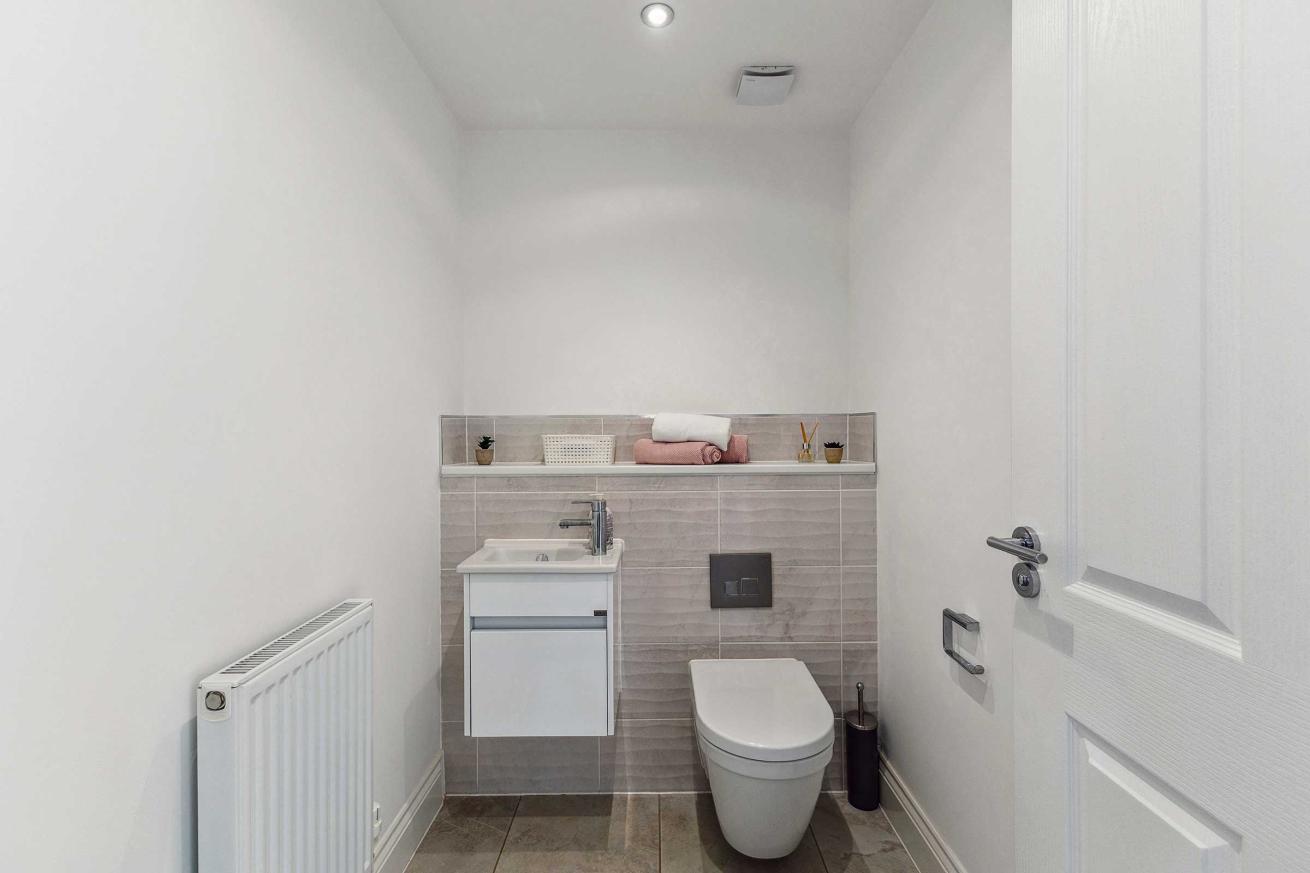  Minimalist WC with wall-mounted toilet and small sink.