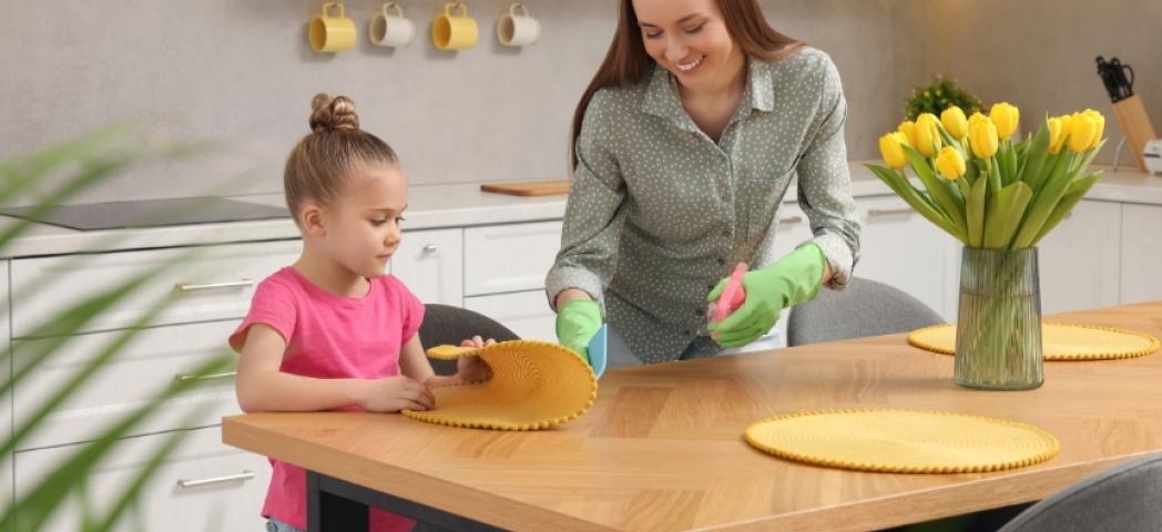 A mother and daughter cleaning their kitchen
