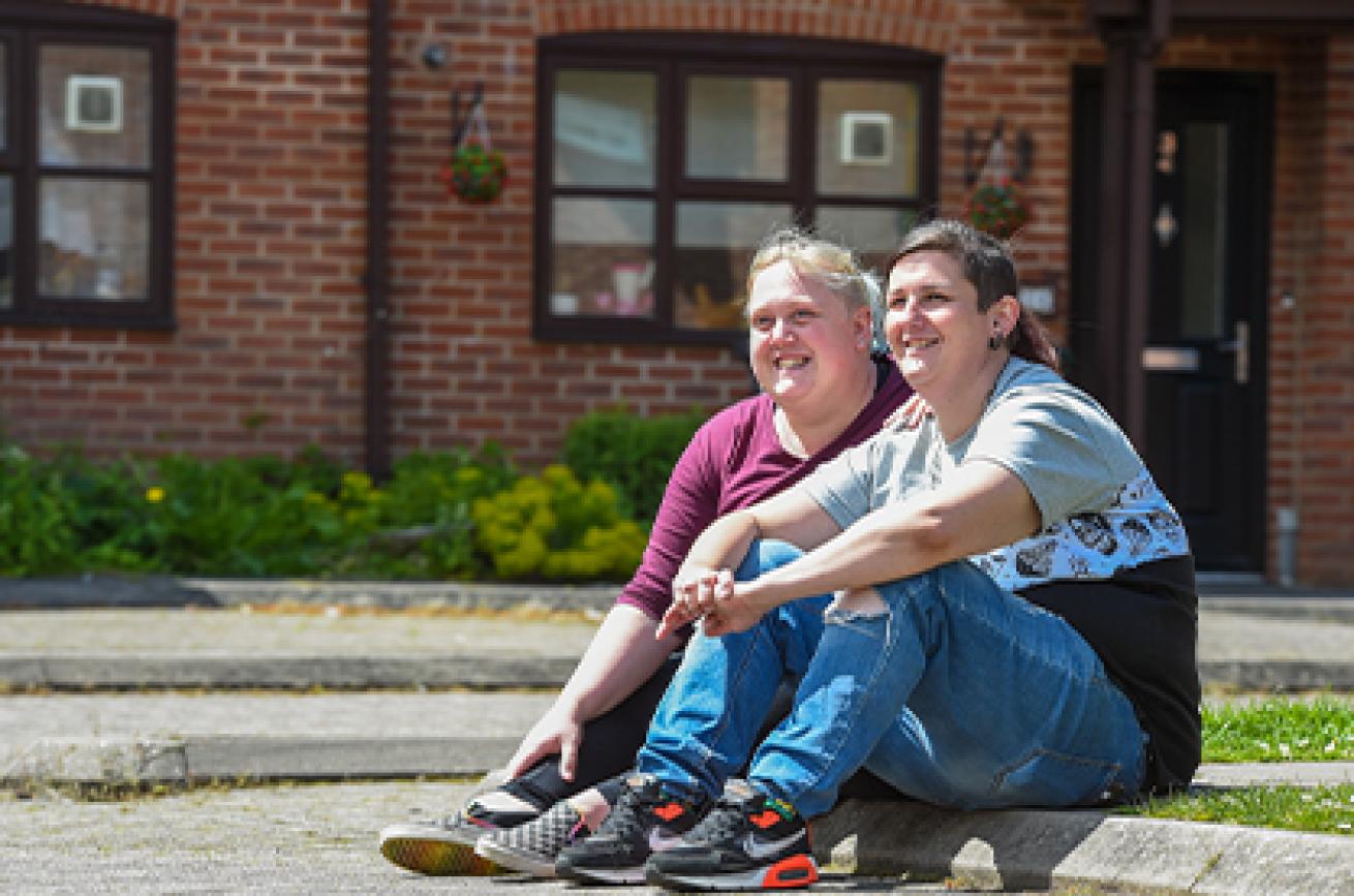 Sanctuary residents siting on a curb