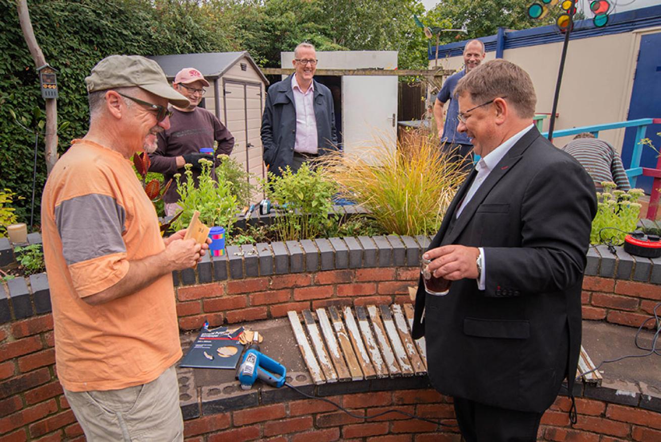 Colin Williams shows Peter Martin how to tune up a piano bench while Kevin Heslop (centre) and volunteers look on