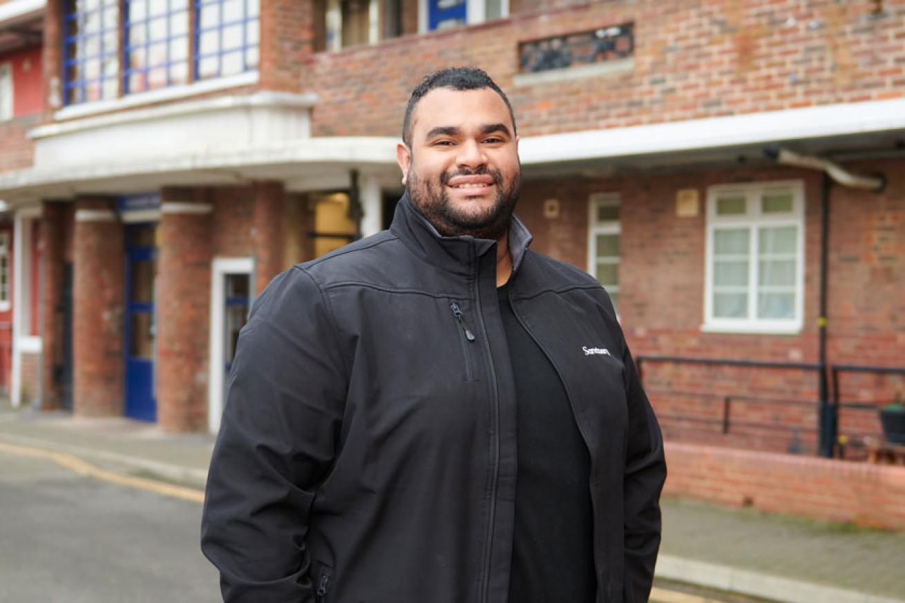 A Sanctuary housing officer stood outside a block of flats A Sanctuary housing officer stood outside a block of flats