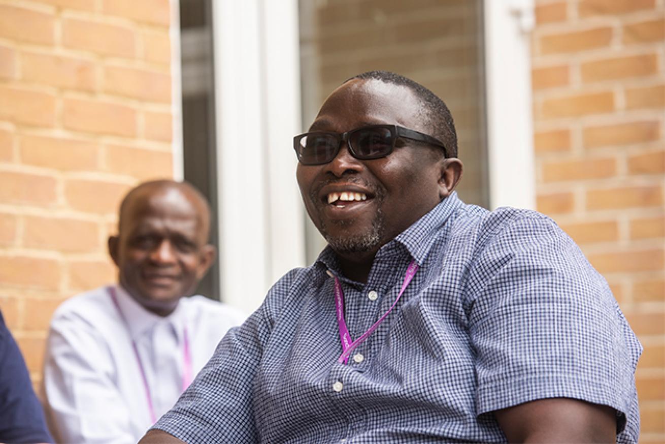 An Sanctuary employee wearing dark sunglasses and a checkered shirt, smiling