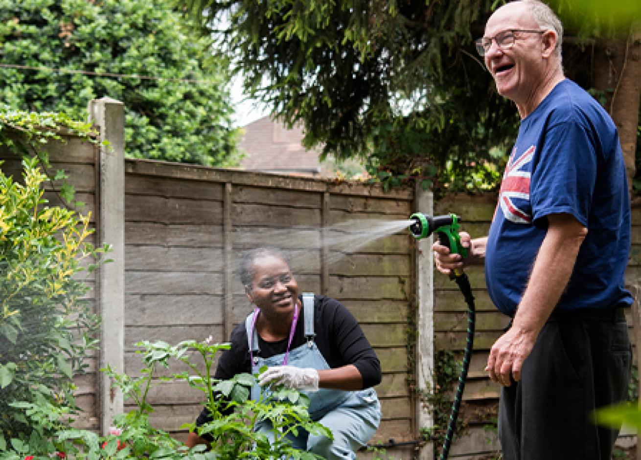Sanctuary Supported Living staff and resident tending to the garden