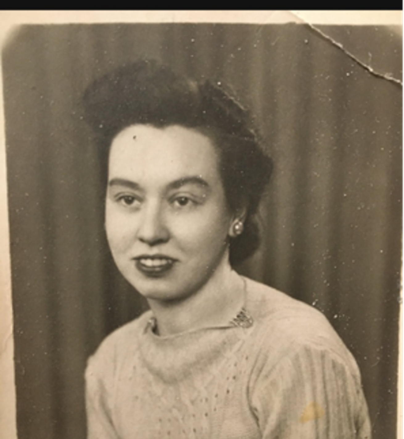 A picture of a monochrome photograph of Tessa, The photograph of Tessa is aged and damaged slightly