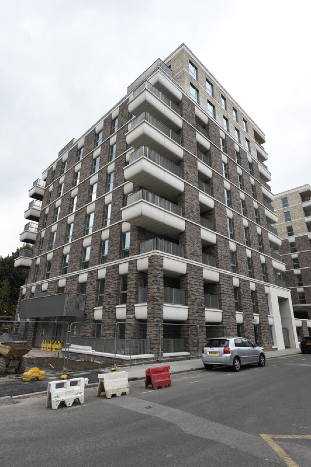 Modern brick apartment building with white balconies in Tower Hamlets, London.