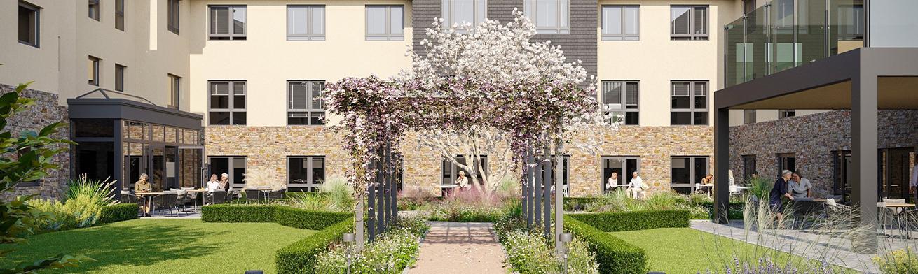 A landscaped courtyard with flowering archway, trimmed hedges, and patio seating near a multi-windowed building used for social or communal activity.