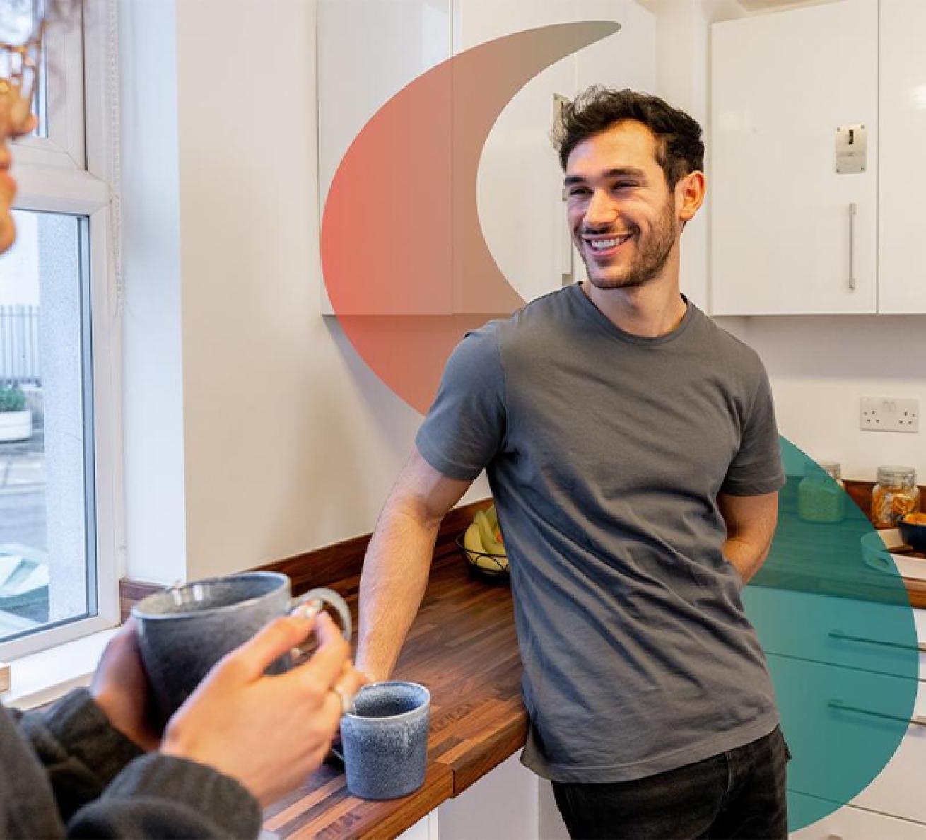 Two people in a bright kitchen, one leaning on a counter and the other holding a mug, with abstract red and teal shapes overlaying the scene.