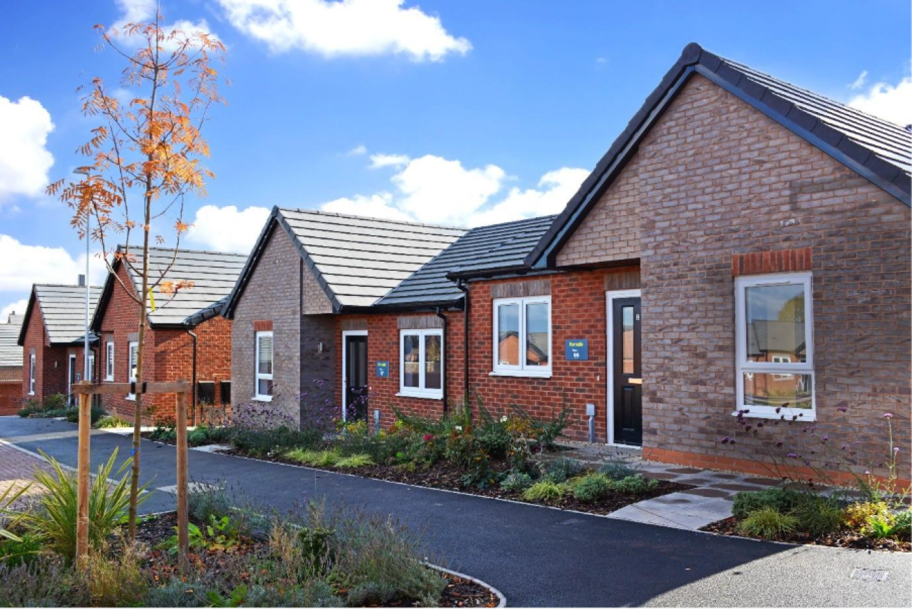 An exterior picture of the Maples development with a grassy verge and path. 