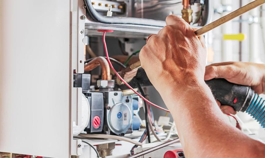 Person servicing a gas boiler Person servicing a gas boiler