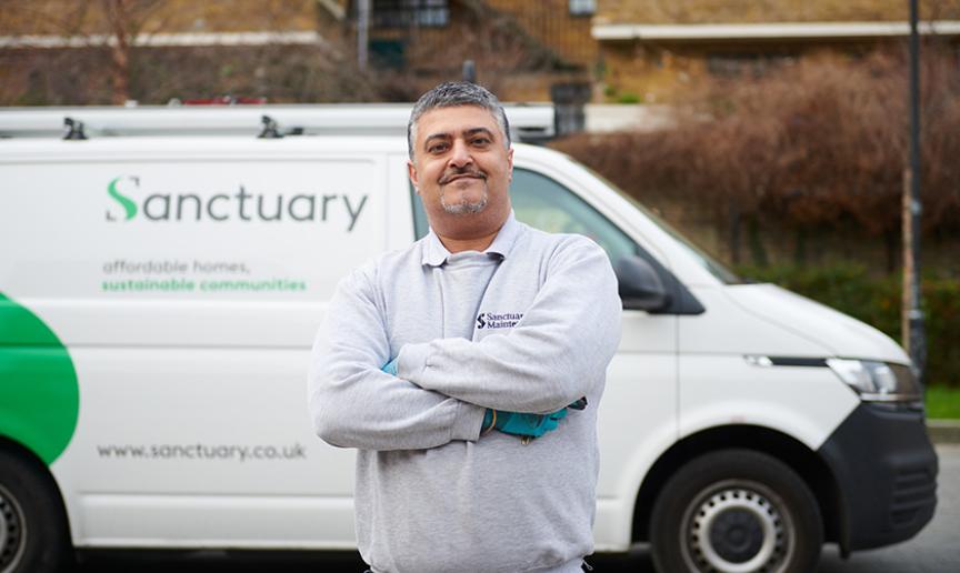 Sanctuary Maintenance employee standing proudly next to a Sanctuary branded van