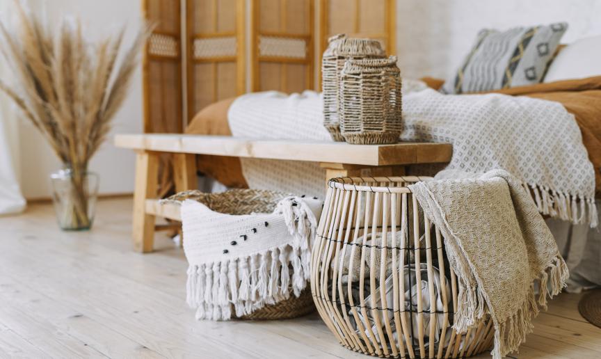 A cozy room featuring a bed, a wooden table, and a basket, creating a warm and inviting atmosphere.