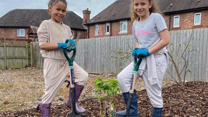 Malika and Tiyana Newey planting a tree at our Lache Growing Space