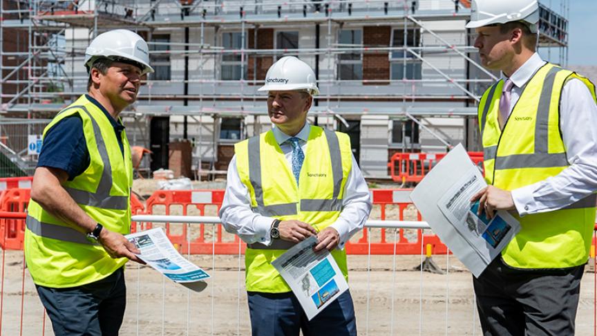 Craig Moule, Nigel Huddleston and Mark Battin in high vis jackets standing in front of the Evesham development.