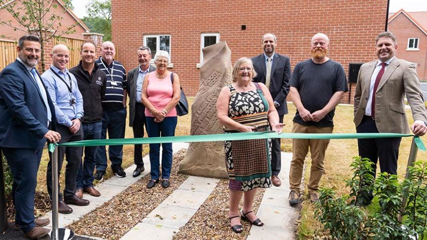 Cllr Jean Innes, joined by other borough and parish councillors, as well as Sanctuary and partner staff, cuts the ribbon on the site