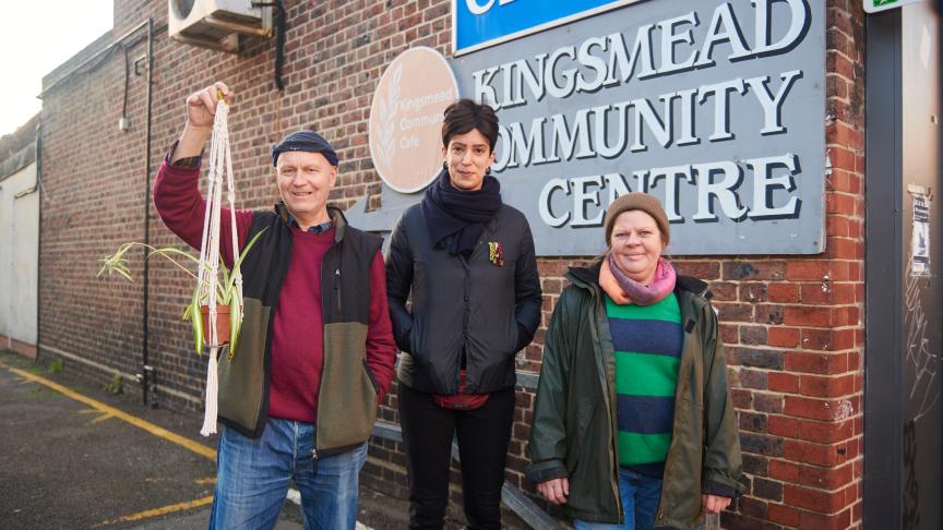 Kingsmead Community Centre gardening group Three people are shown in front of a sign reading Kingsmead Community Centre