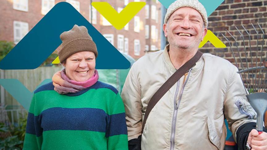 Two residents smiling, standing in an allotment Two residents smiling, standing in an allotment