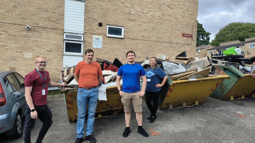 Sanctuary staff stand in front of several full skips