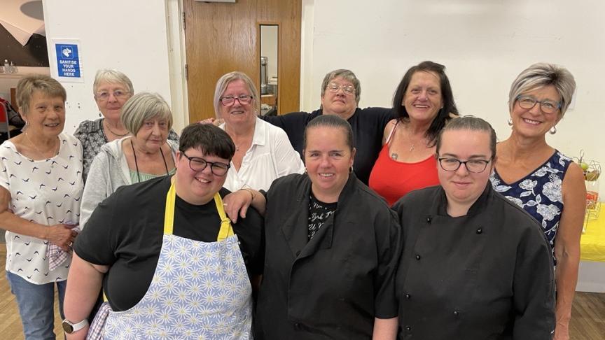 Blether cafe volunteers A group of people standing in a community centre smiling
