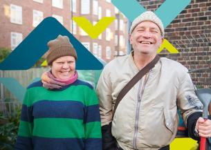 Two residents smiling, standing in an allotment