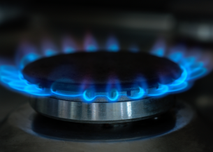A lit gas hob with blue flames