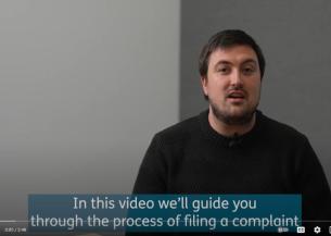 A man talks to the camera, captions read 'In this video we'll guide you through the process of filing a complaint'