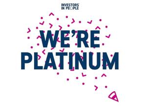Graphic with the Investors in People logo at the top and bold text reading 'We’re Platinum' in dark blue, surrounded by pink confetti shapes on a white background.