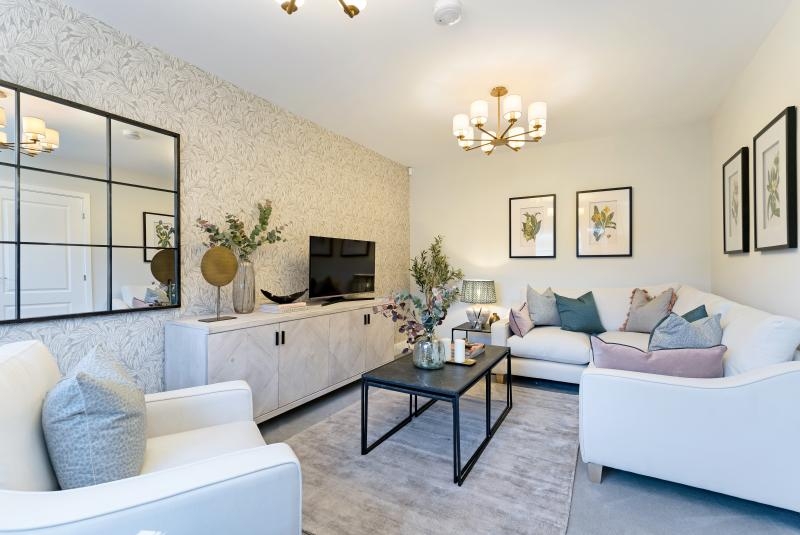 A white walled living room with plush white sofas and a large gridded mirror with black framing